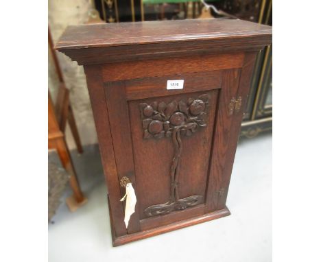 Early 20th Century Art Nouveau style oak wall cupboard, the single door having carved fruiting tree decoration, 64cm highGood