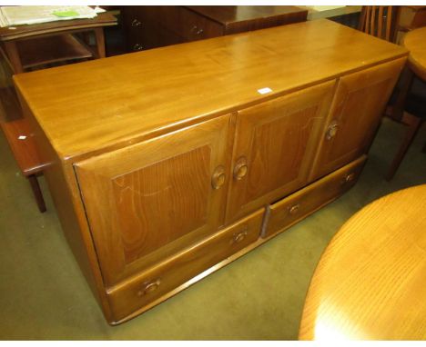 Ercol light ash sideboard, having three panelled doors with two drawers, on casters, 76cm high x 130cm wide x 45cm deep 