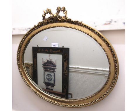 Oval gilt framed wall mirror with bevelled plate, together with a reproduction mahogany wall hanging corner cabinet with glaz