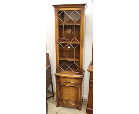 Reproduction mahogany slender display cabinet having moulded cornice above a bar glazed door enclosing adjustable shelves, wi