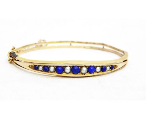Gold, pearl and lapis lazuli bangle, the elliptical top set with alternating pearls and lapis lazuli (PLEASE NOTE NEW ESTIMAT