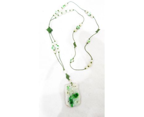 Chinese jade pendant of rectangular form, carved with dogs of fo using the stone's green highlights against a paler backgroun