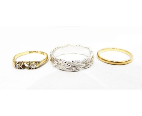 18ct gold and three-stone diamond ring (centre stone missing), an 18ct gold wedding ring, a white metal leaf-patterned ring a