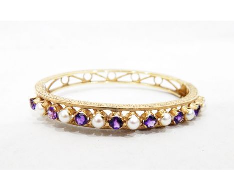 Gold hinged bangle set with 15 alternating round mixed cut amethysts and split pearls, with engraved and pierced decoration 