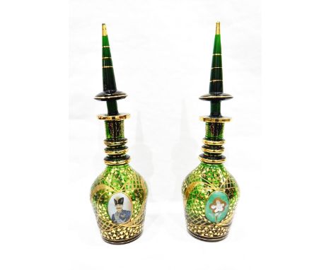 Pair of green ground Bohemian ring neck decanters, having tall tapered stoppers, engraved and gilt decorated with circular ca