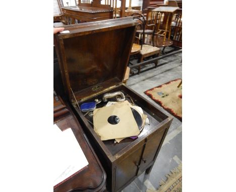Dulceola gramophone, the rising top enclosing the turntable, pair of cupboard doors below enclosing speaker box and open shel