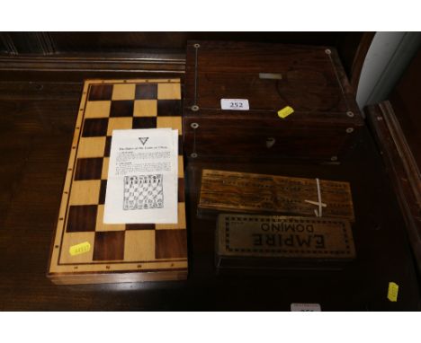 A rosewood and mother of pearl inlaid trinket box; a set of dominoes, a crib board and a chess board