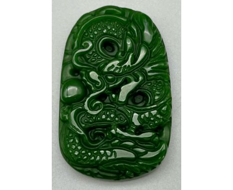A Carved Dragon Decorated Green Jade Pendant. 3.5 x 5cm. 