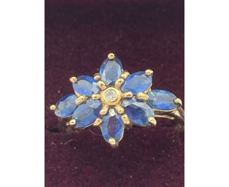 Beautiful 9 carat GOLD, SAPPHIRE and DIAMOND RING, having diamond point to centre with an eight sapphire surround. Full UK ha