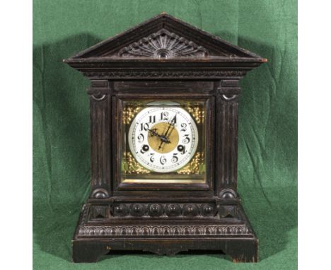 A brass faced, oak cased mantle clock