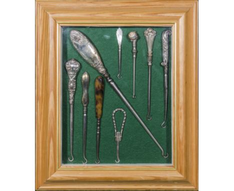 A mounted and framed collection of silver and agate handled button hooks