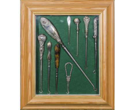 A mounted and framed collection of silver and agate handled button hooks