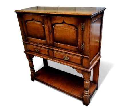 Attributed to Titchmarsh &amp; Goodwin, a Jacobean Revival oak buffet, the carved doors with arcade motifs, opening to reveal