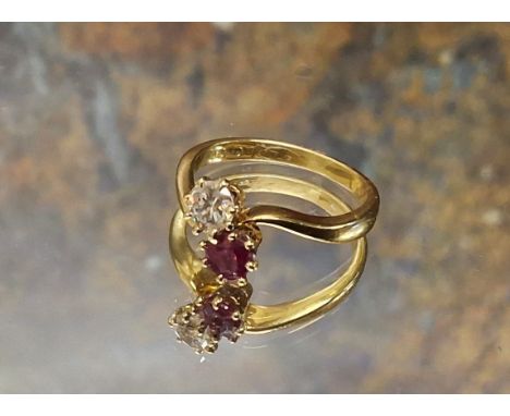 An 18ct gold diamond and ruby ring, the claw set diamond approx 0.25ct and the round ruby set on a twist, size K, 3.1g gross 