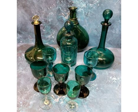 A 19th century bottle shaped emerald decanter, Scotch stopper, 25.5cm high, c.1850; another; a wrythen cylindrical decanter, 