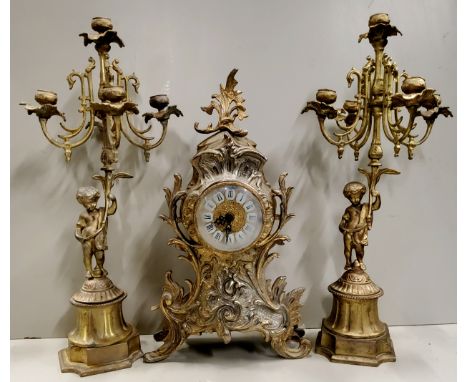 A Louis XV style Frech gilded metal mantel clock with candelabras, clock 40cm high, 20th century. 