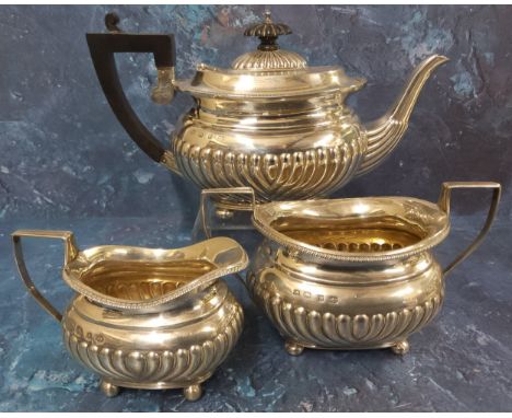 A Victorian silver three piece half fluted boat shaped bachelors tea service, comprising teapot, twin handled sucrier, and mi