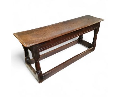 An early 17th century Charles I English oak&nbsp;bench or long joint stool, moulded top above a deep fluted frieze, carved tu