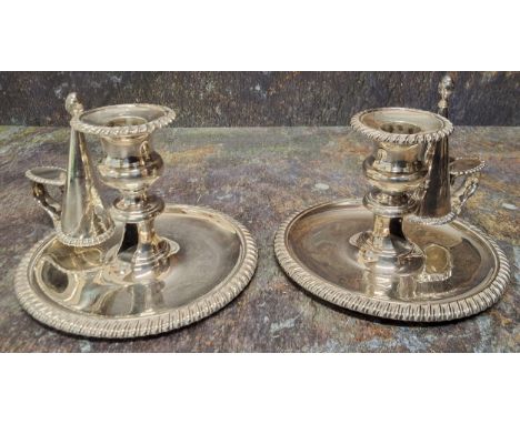 A pair of George IV silver chambersticks, campana sconces, dished circular bases, scroll handles with thumb-rests, gadrooned 