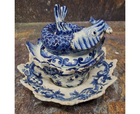 A Dutch Delftware fish sauce tureen, cover and stand, Jan van der Kloot, painted in shades of cobalt with scrolling foliage a