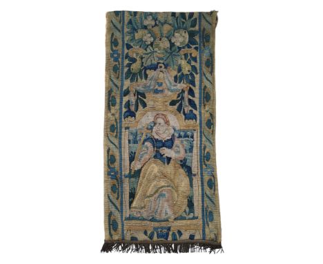 A late 17th century/early 18th century woolwork tapestry fragment, embroidered with lady holding a cross, below stylised frui