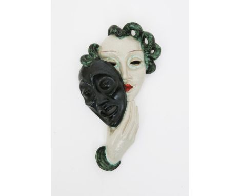 'Comedy' a large Goldscheider Pottery wall mask, model no.6280, modelled as a woman holding a mask, glazed black, white, gree
