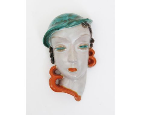 A Goldscheider Pottery mask of a woman wearing a blue beret, model no. 6537, painted in shades of turquoise, brown, orange an