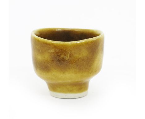 •Dame Lucie Rie D.B.E. (1902-1995) a miniature footed vase, covered to the foot with a mustard yellow glaze impressed seal ma