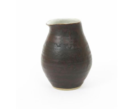 •Dame Lucie Rie D.B.E (1902-1995) a stoneware pouring vessel, ovoid with pulled rim, covered in a manganese glaze over grey i