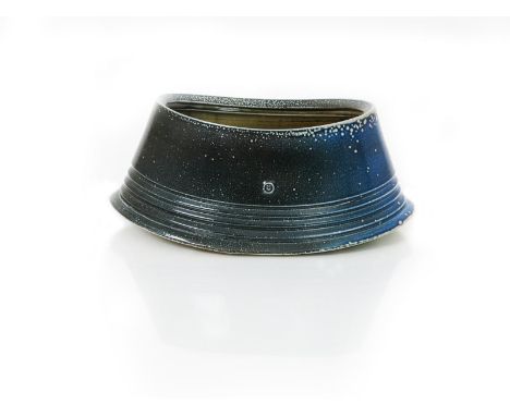 •Walter Keeler (born 1942) a salt-glaze stoneware trough vase,  elliptical form, covered in a blue glaze, the interior mustar