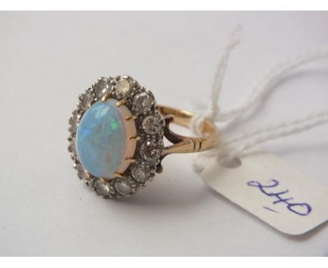 LARGE MOUNTED COLOURFUL OPAL   11mm long surrounded by 12 good size diamonds  in 18ct gold mount ring size N  7.6g inc    