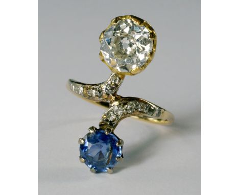 An 18ct gold, diamond and sapphire cross-over ring, early 20th century, the old cut diamond, approx 1.21ct, G-H colour and SI