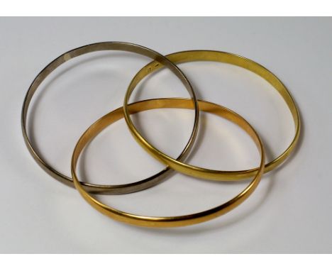 Cartier: A Trinity tri-colour 18ct gold interlocking bangle, signed Cartier, approx 6.5cm diameter, approx 56.5g. CONDITION R