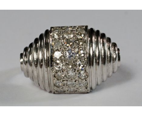 A white metal and diamond set cocktail ring, of shaped, ribbed and domed form, with a central three row band of diamonds, app