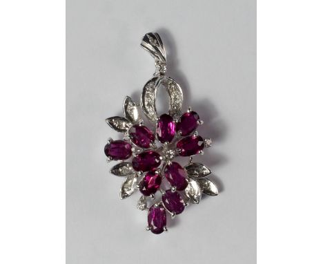 An 18ct white gold, ruby and diamond set pendant, of abstract flower head form, approx 3.5cm long, approx 4.7g.
Provenance: T