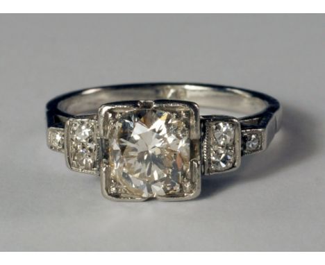 An Art Deco platinum and diamond set ring, c.1930s, the central diamond approx 1.0ct, in stepped mount flanked by further dia