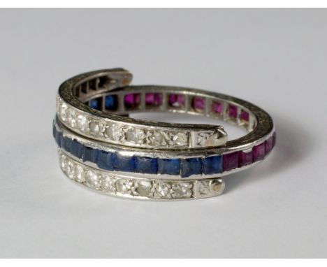 A diamond, ruby and sapphire eternity swivel ring, the engraved white metal band channel set halfway with square cut rubies, 