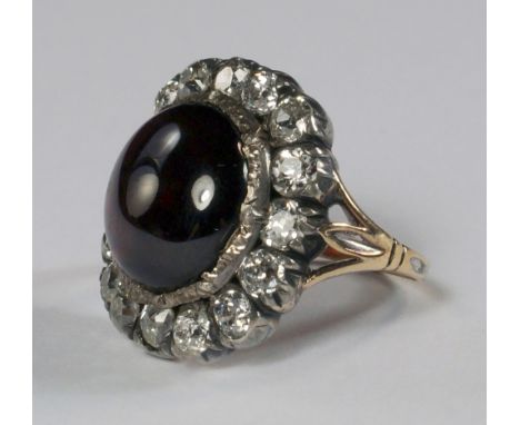 A Georgian garnet and diamond ring, the large cabochon garnet with a border of sixteen old cut diamonds, approx 1.00ct total,