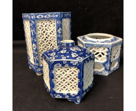 Three Chinese blue and white porcelain cricket cages, rice grain piercing, decorated with prunus flower motifs, 12.5cm high a