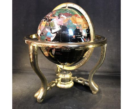 A table top globe, the countries of The World picked out in coloured stone and shell on a black ground, the brass finish trip