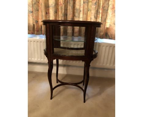 An Edwardian kidney shape mahogany vitrine, the display case with one internal glass shelf and inlaid with ribboned laurel wr