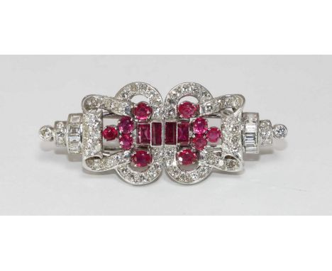 An early 20th century White Gold, Diamond and Ruby double-clip brooch, formed as a scrolled cartouche, set with four emerald-