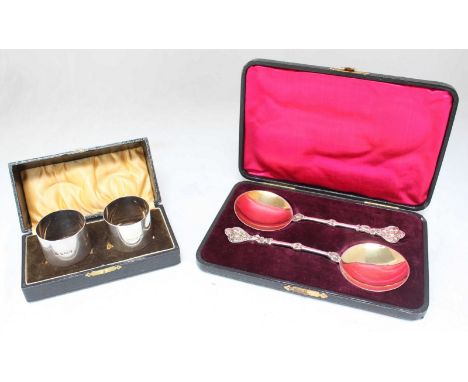 A pair of late Victorian silver and silver-gilt spoons, cartouche finials with masks and shallow round gilt bowls, London, 18