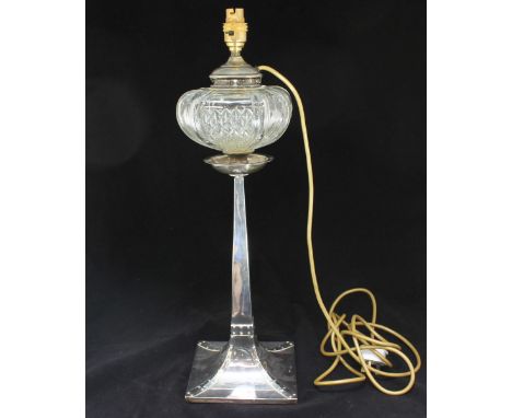 An Arts and Crafts silver oil lamp base by 'George Edward & Sons' converted to an electric lamp, with moulded glass bowl, rai