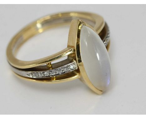 An 18ct yellow and white gold ring, centrally set with an oval cabochon moonstone and the central white gold band set with di