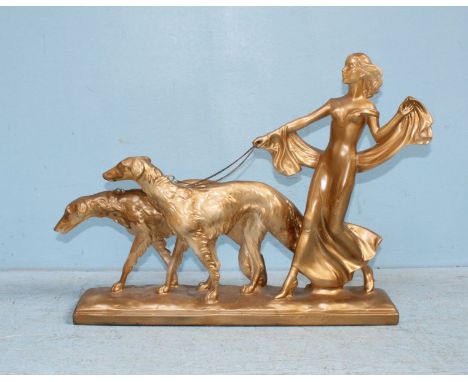 A 1930's Art Deco figure of a lady walking two dogs, later painted gold. 54cm long.