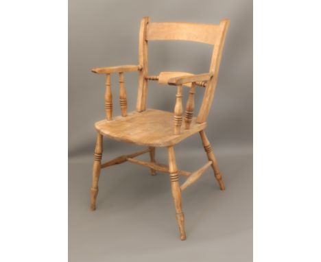 A beech tablet-back armchair - the armrests and saddle seat united by ring turned supports, the legs united by an H-form stre
