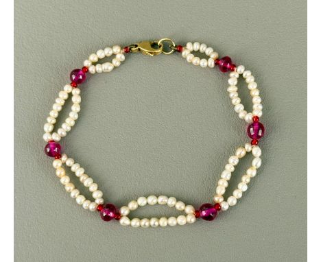 A 9ct gold, pink stone and seed pearl bracelet - the lobster claw clasp stamped '9K', with seven graduated ovals of seed pear