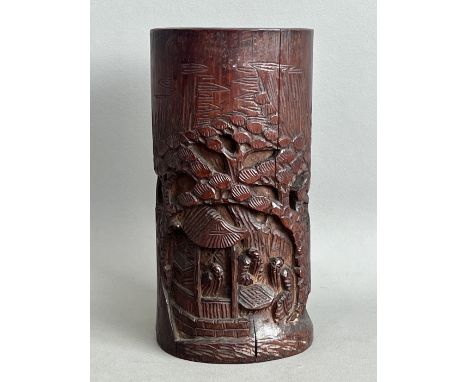 A Chinese carved bamboo brush pot - probably 19th / early 20th century, carved with figures seated beneath a pagoda in a wood