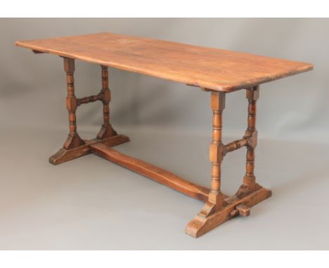 An oak and stained beech dining table - the rectangular top raised on turned H-supports united by a centre stretcher, on sled
